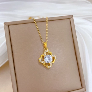 Detailed view of a gold clover necklace with crystal inlay on a jewelry box display