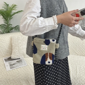 Détail du sac bandoulière en peluche avec motif chien et sangle à pois sur modèle