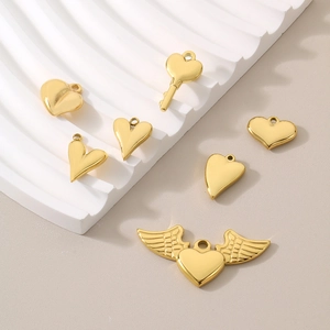 Set of seven gold heart-shaped stainless steel pendants including key and wing designs