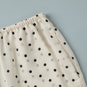 Detail of elastic waist and black polka dot pattern on beige chiffon fabric summer set