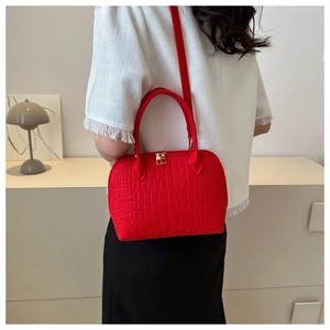 Detail of red stone texture shell bag with golden zipper and detachable shoulder strap