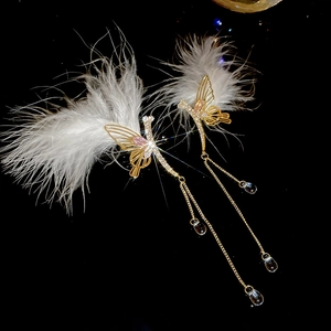 Detail of elegant feather butterfly earrings with sparkling crystals and long tassels