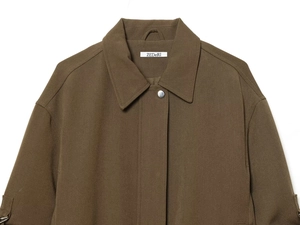 Detail of dark brown aviator jacket showing lapel collar with single metal buckle button