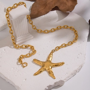 Statement gold starfish pendant necklace with heavy chain link on a stone texture base