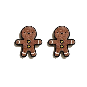 Detailed macro shot of gingerbread man wooden stud earrings for Christmas festive jewelry