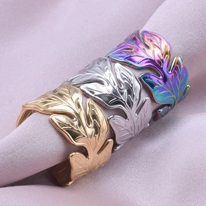 Detailed view of three leaf-shaped adjustable rings in gold silver and rainbow finishes