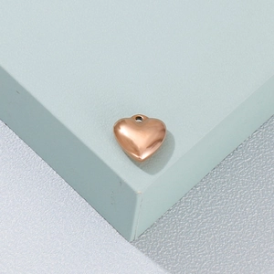 Vue macro d'un pendentif cœur en or rose poli sur un bloc d'affichage géométrique