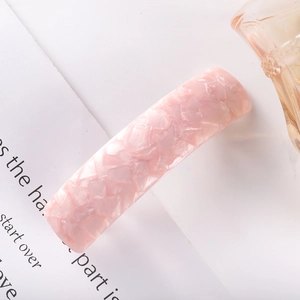 Close-up of pink checkered acetate hair clip with iridescent shell texture detail