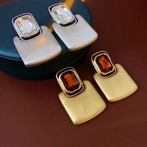 Rectangular brushed metal drop earrings with silver and gold finish featuring inset crystals