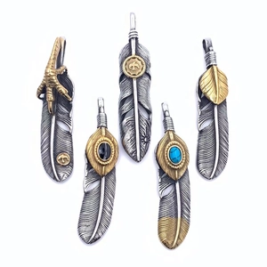 Detailed array of titanium steel eagle claw and turquoise feather pendants in gold and silver