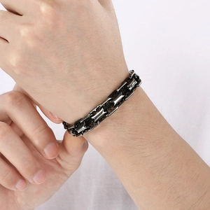 Gros plan d'un bracelet gourmette en acier inoxydable noir avec fermoir magnétique au poignet