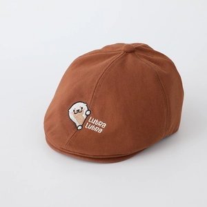 Détail du béret en coton marron avec broderie de loutre blanche et texte Lutra Lutra