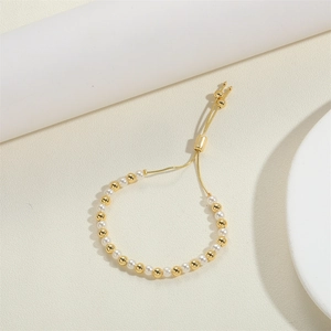 Detail of adjustable sliding gold clasp and alternating pearls on a 14K beaded bracelet