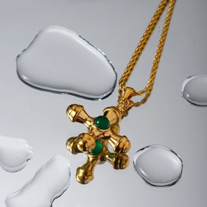 Detail of 18k gold stainless steel cross necklace with a green tiger eye gemstone and water drops