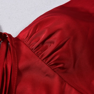 Gros plan d'une robe en satin rouge avec des plis élégants et de fines bretelles
