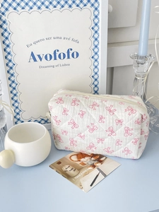 Detailed view of quilted cotton makeup bag with pink bow pattern and metal zipper closure