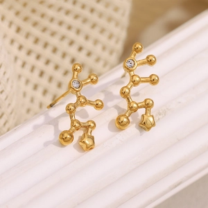 Macro detail of 18K gold plated constellation earrings with rhinestones and star pendant