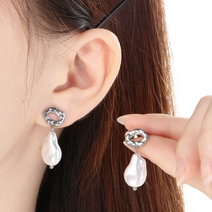 Detailed close-up of Baroque irregular pearl earrings worn on a female model