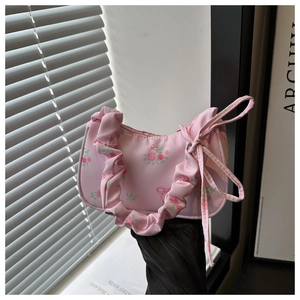 Detailed shot of pink floral shoulder bag with ruched handle and ribbon bow detail