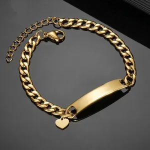 Close-up of golden stainless steel Cuban ID bracelet with curved plate and heart charm