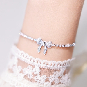 Close-up of sparkling bow-tie tennis bracelet with micro-pave crystals on a female wrist
