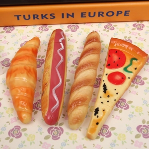 Macro shot of realistic pizza, hot dog, and croissant shaped novelty ballpoint pens