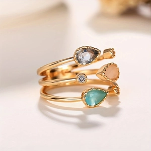 Detailed view of triple-layer gold open ring featuring colorful pear-cut gemstones