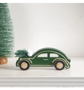 Close-up of wooden dark green Christmas car decor with mini pine tree and gold glitter details