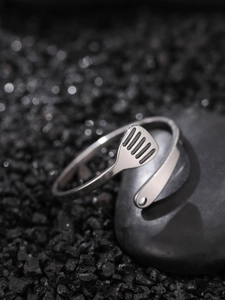 Macro detail of adjustable stainless steel glowing ring on dark textured stones