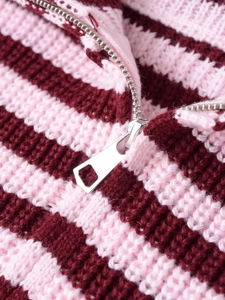 Détail macro de la fermeture éclair en métal argenté sur la veste en maille rayée rose