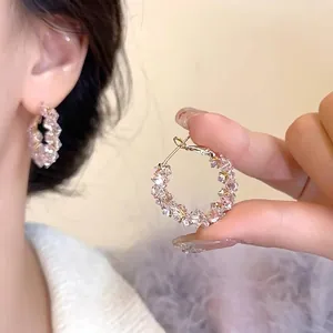 Detail of luxury round crystal hoop earrings with pink gemstones and gold metal buckle
