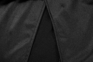 Close-up of black summer dress showing slit design detail and premium woven texture