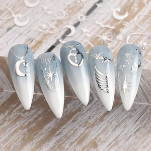 Détail de stickers nail art argentés avec motifs lune et étoile sur ongles dégradés