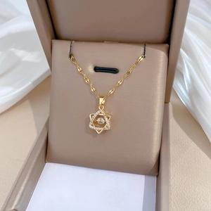 Detailed view of a gold star necklace with inlaid crystals in a brown jewelry gift box