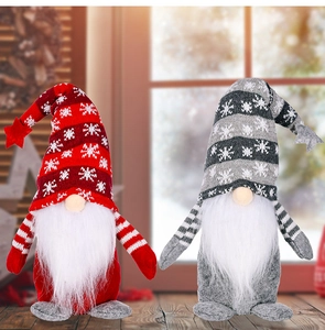 Detail of two Christmas gnomes with snowflake knitted hats and white beards in cozy setting