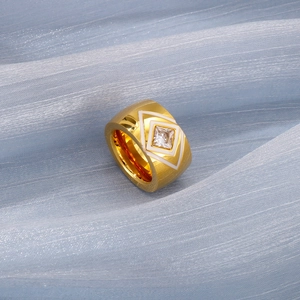 Detailed macro view of a gold-plated wide ring with white enamel and a square zircon stone