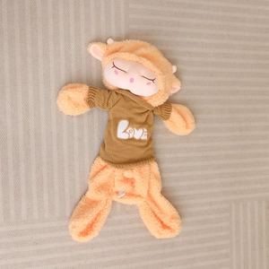 Detail of plush sheep toy in orange fuzzy fabric wearing a brown Love knitted sweater