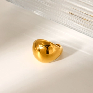 Detailed close-up of a polished gold chunky ring with a minimalist dome design on white background