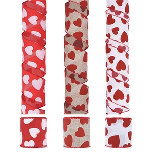Macro view of three heart pattern ribbon rolls in red, beige and white for gift wrapping