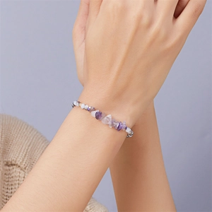 Detail eines handgefertigten Amethyst-Armbands am Handgelenk mit weicher Beleuchtung