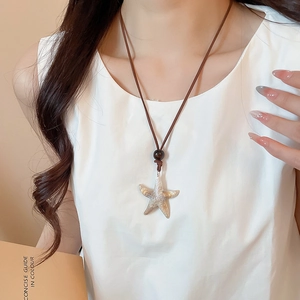 Close-up of a realistic starfish pendant with brown cord and wooden bead details