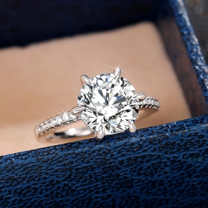 Detail of a six-prong sparkling zircon engagement ring in a luxury velvet jewelry box