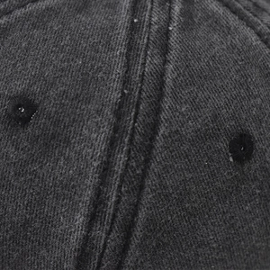 Macro view of dark grey washed cotton twill fabric and stitching on baseball cap