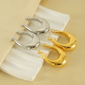 Polished 18K gold and silver chunky teardrop earrings on white and satin base