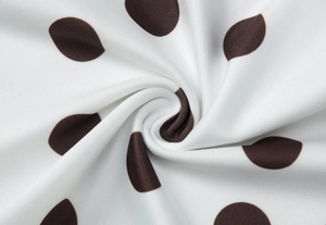 Vue macro d'un tissu en polyester blanc à pois marrons avec des plis drapés doux