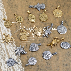 Vintage gold and silver steel pendants with sun, angel, and heart charms on lace paper