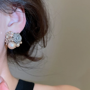 Detail view of flower pearl earring with crystals and vintage metallic floral design