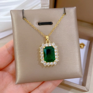 Macro shot of an emerald green square pendant with white zircon halo on gold chain
