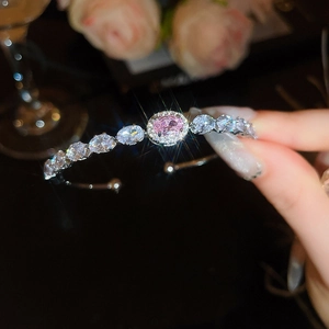 Detailed view of silver cuff bracelet featuring oval pink stone and brilliant zircon gems