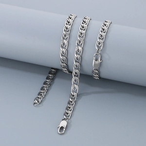 Macro detail of silver paperclip chain necklace with lobster clasp on grey stand